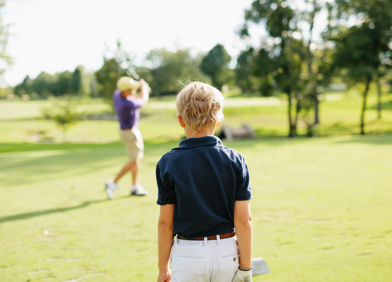 A young boy is playing golf with his father at Saltleaf Golf Preserve in Bonita Springs.