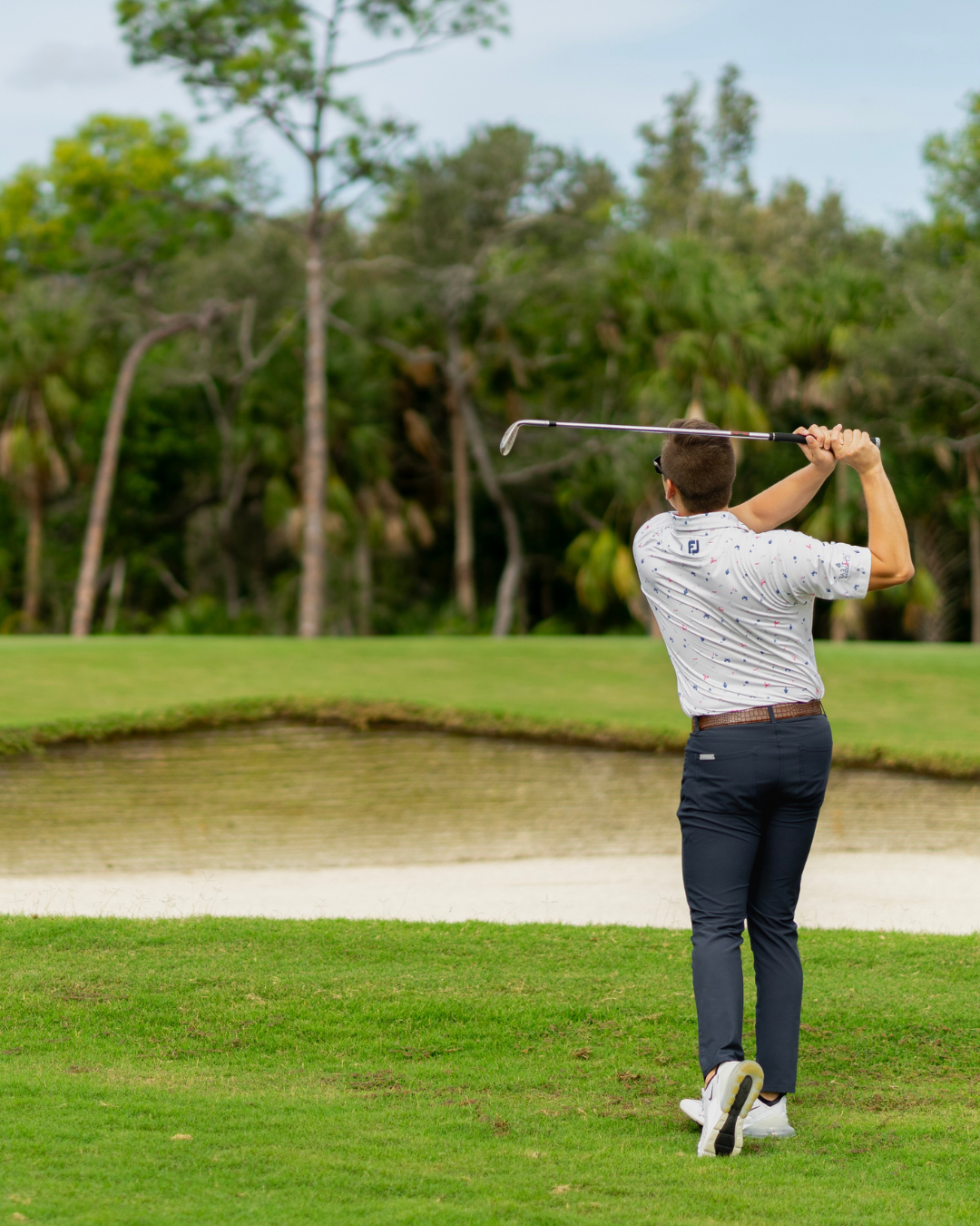 A man swinging a golf club on the Saltleaf Golf Preserve, a championship golf course in Bonita Springs.