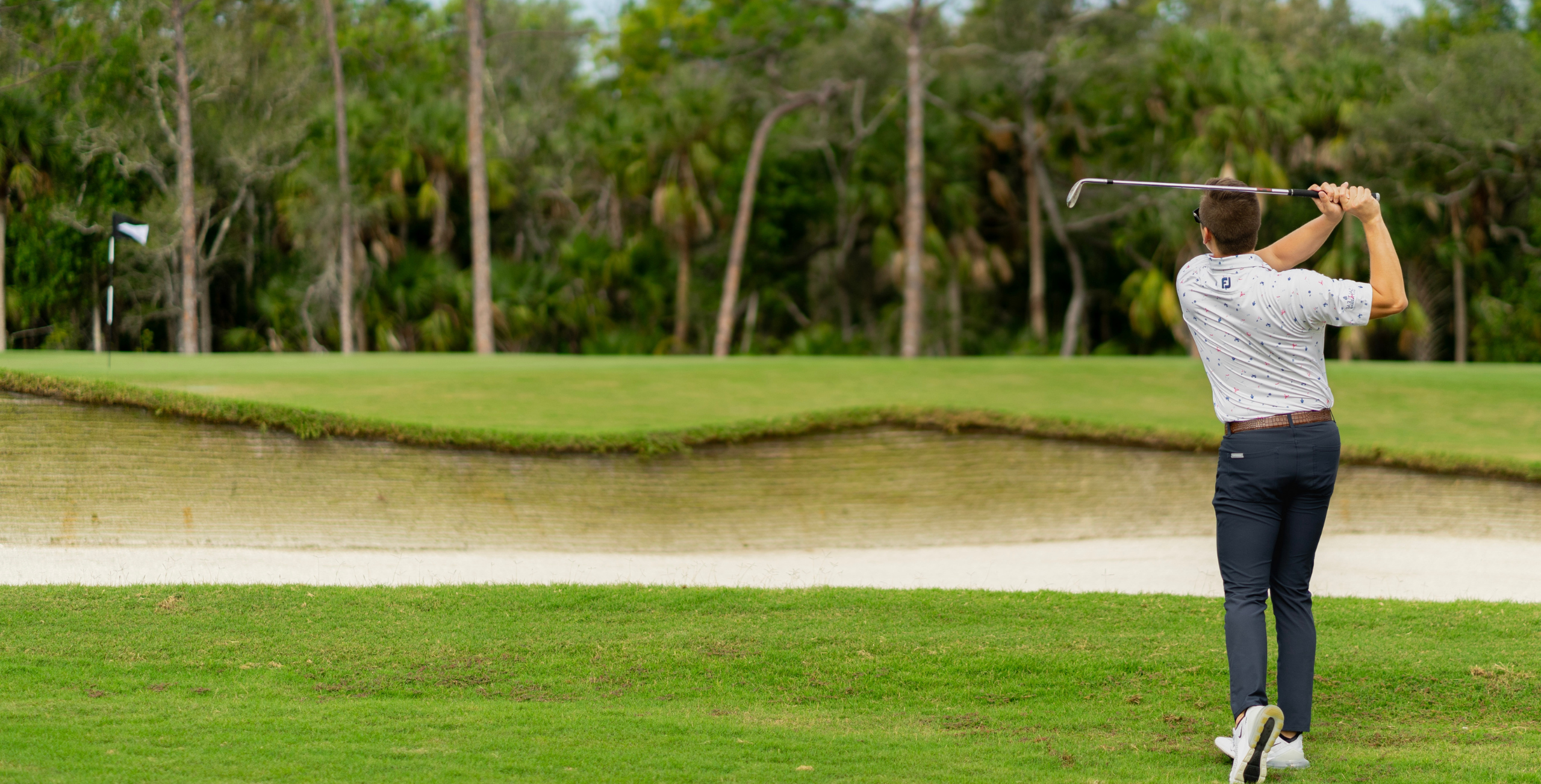 A man swinging a golf club on the Saltleaf Golf Preserve, a championship golf course in Bonita Springs.