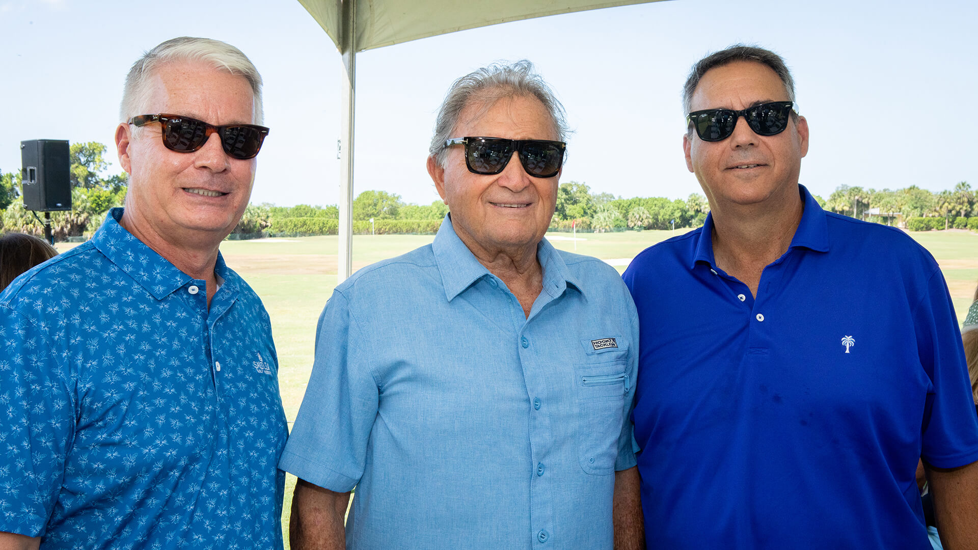 Three men in sunglasses posing for a photo at Saltleaf Golf Preserve event.