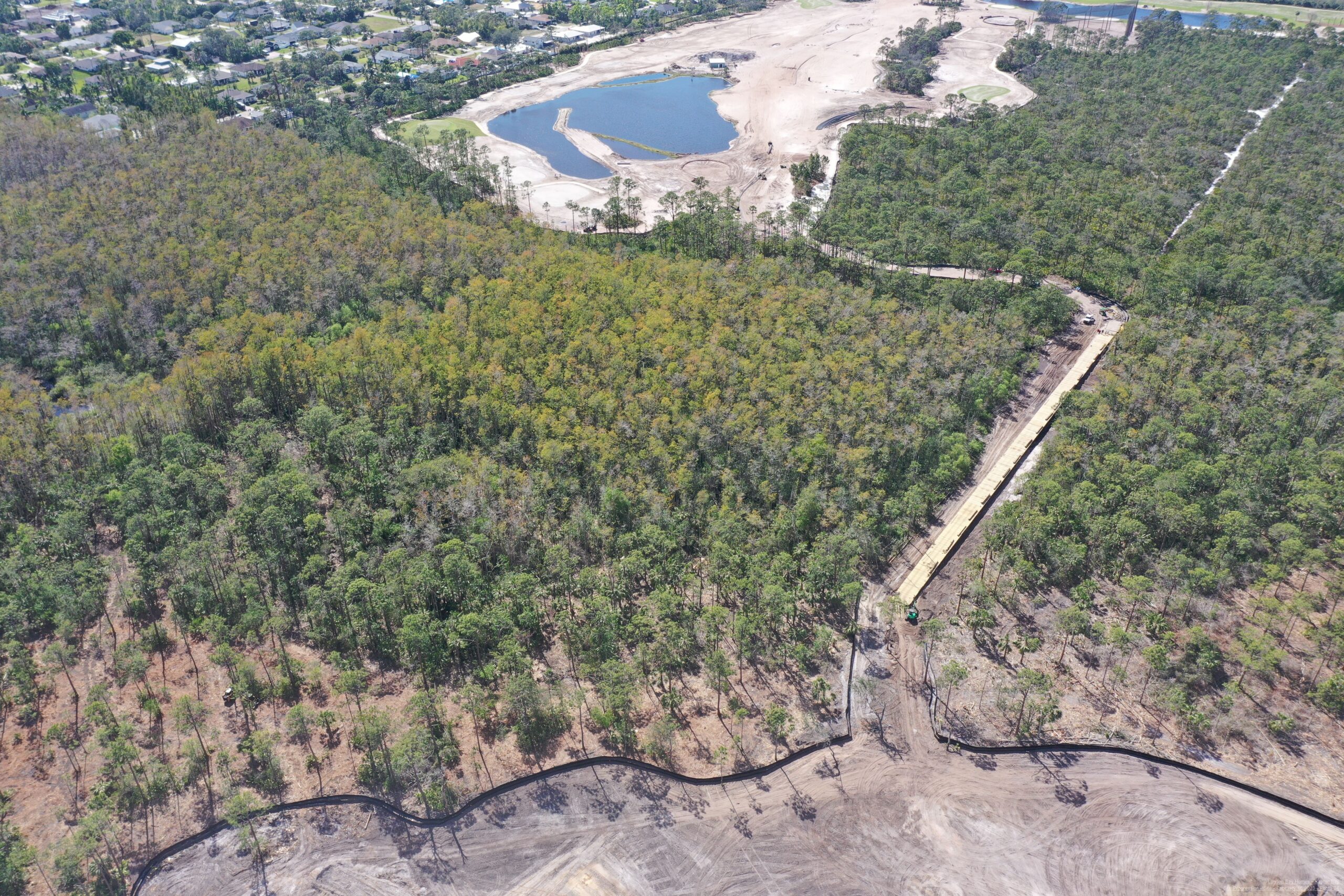 An aerial view of the Saltleaf Golf Preserve, a championship golf course located in Bonita Springs amidst a forest.