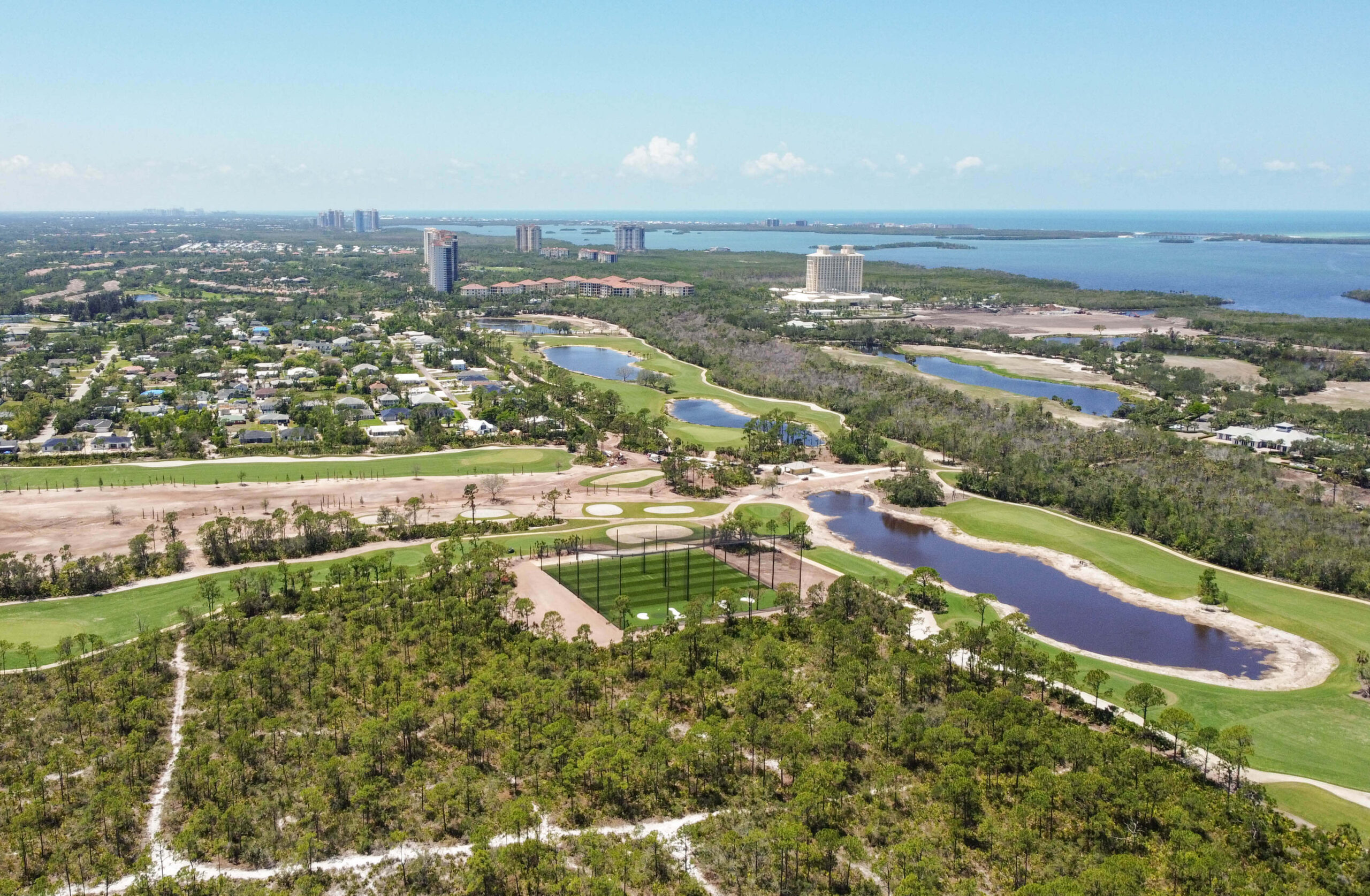 Aerial image of the netted driving range at Saltleaf Golf Preserve with nature and water in the background
