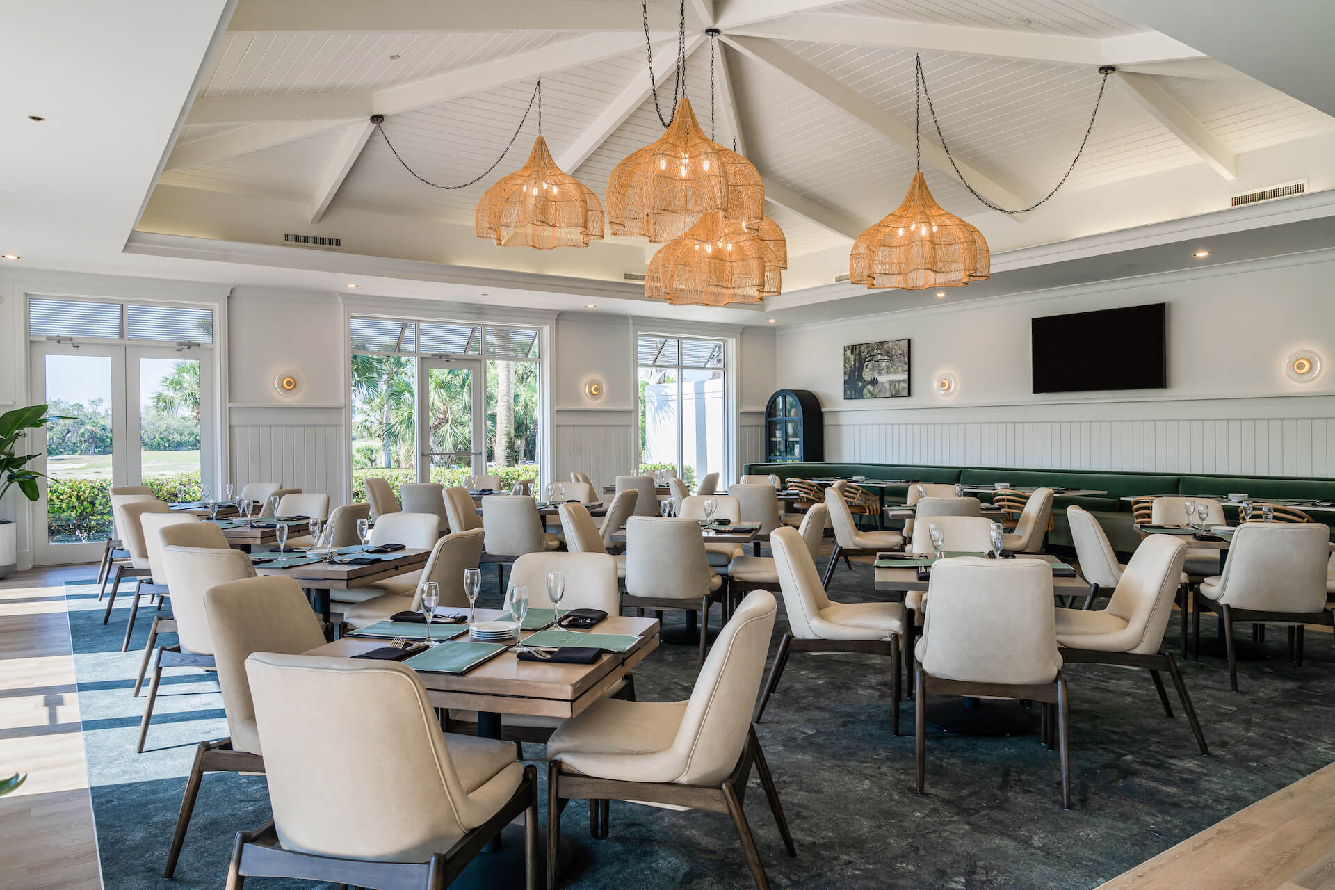 Dining room with tables and modern lighting at the restaurant within the clubhouse at Saltleaf Golf Preserve