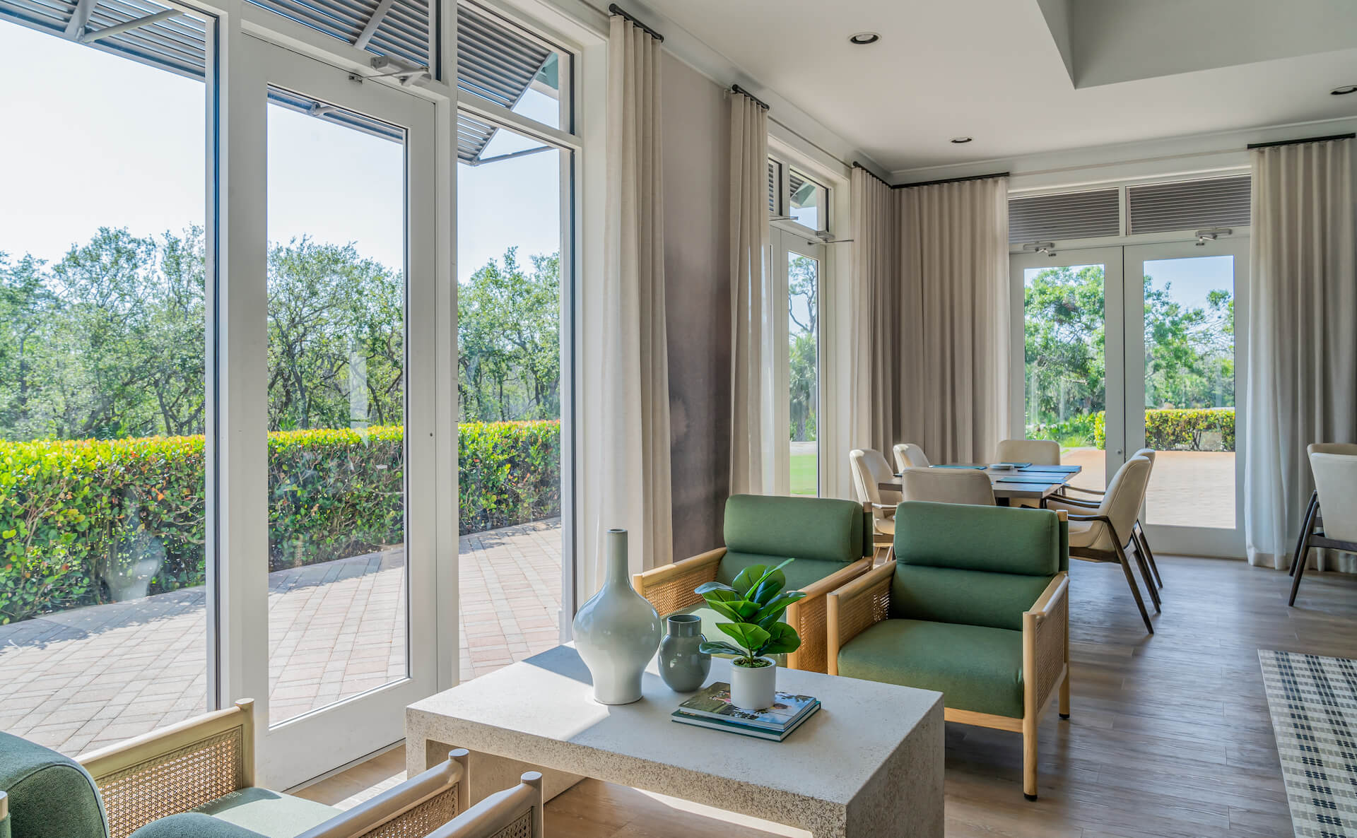 Seating area near big windows overlooking greenery in the clubhouse at Saltleaf Golf Preserve