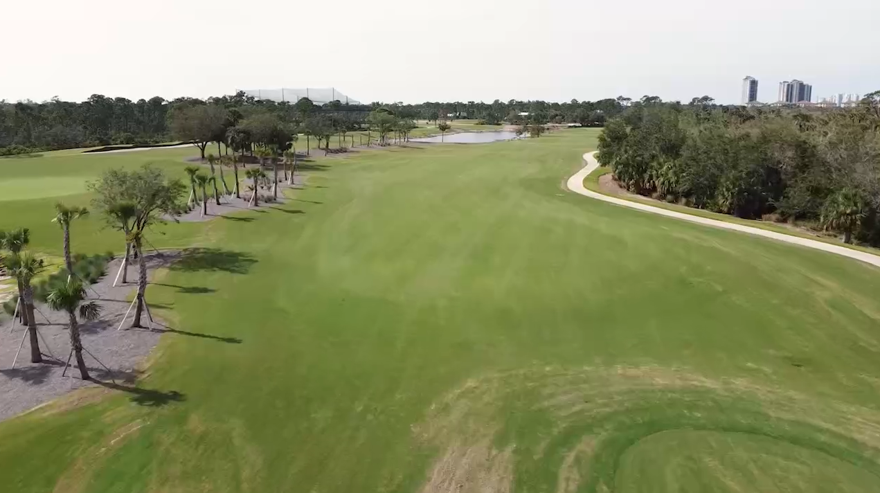 An aerial view of the championship golf course at Saltleaf Golf Preserve in Bonita Springs, surrounded by palm trees.