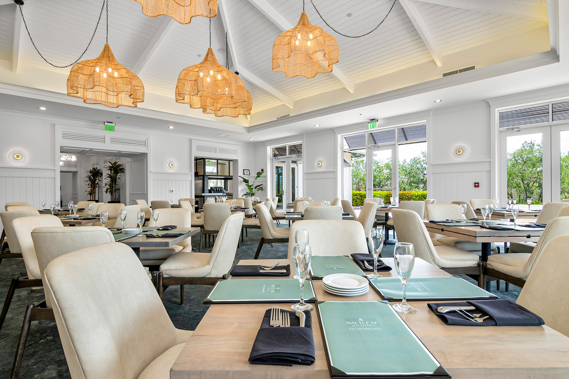 A restaurant with white tables and chairs located in Bonita Springs, near the Saltleaf Golf Preserve.