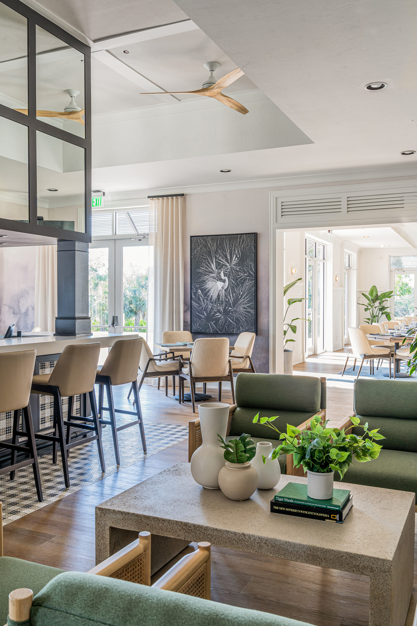A living room with cozy couches and a coffee table overlooking the breathtaking views of the championship golf course at Saltleaf Golf Preserve in Bonita Springs.