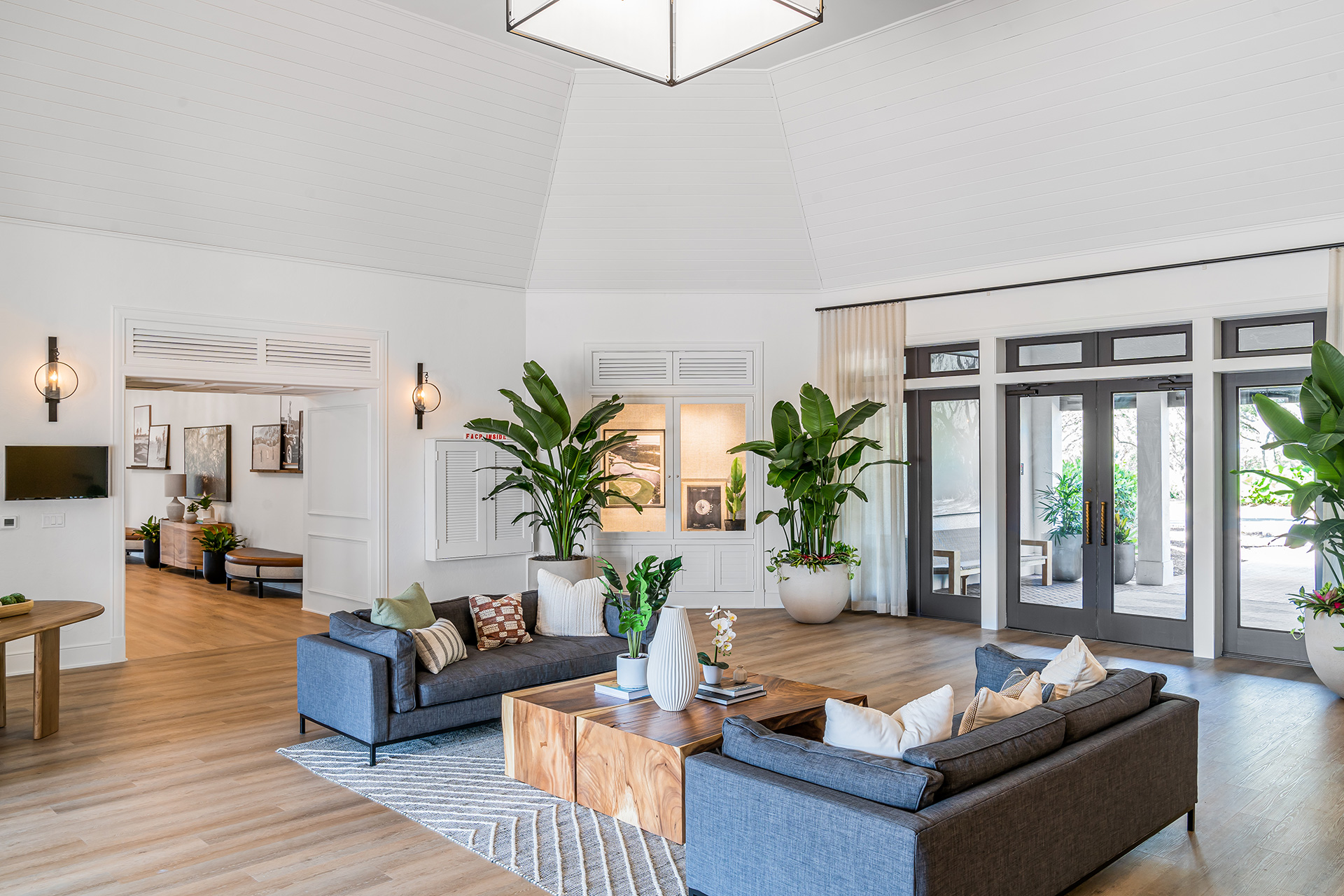 A living room with large windows overlooking the Saltleaf Golf Preserve, showcasing the beautiful championship golf course in Bonita Springs.