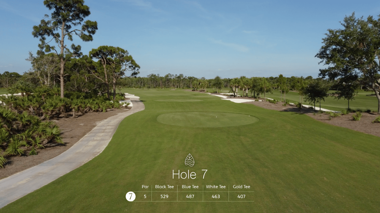Aerial view of Hole 7 on a golf course, showing the green, sand bunkers, a paved path, and distance information for various tee colors.